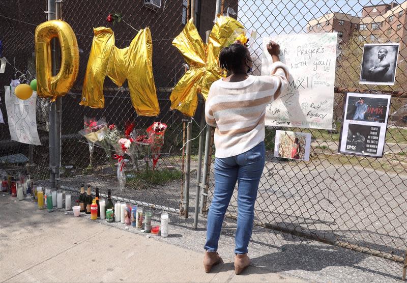 A mourner signs a poster at a memorial for DMX outside White Plains Hospital April 9, 2021.