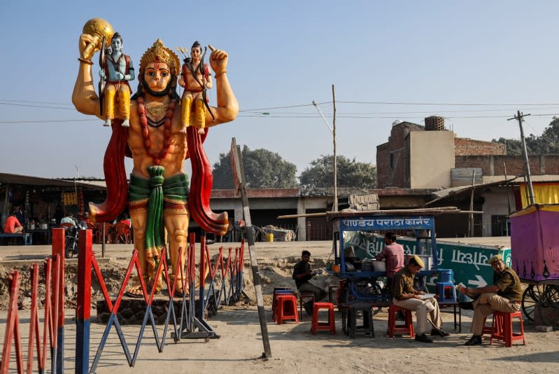 A statue of Hindu monkey god Hanuman is seen next to security barricade as police officers take a break after Supreme Court's verdict on a disputed religious site, in Ayodhya