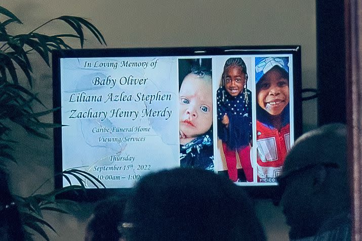 A screen inside the Brooklyn funeral home shows the pictures and names of the three victims.