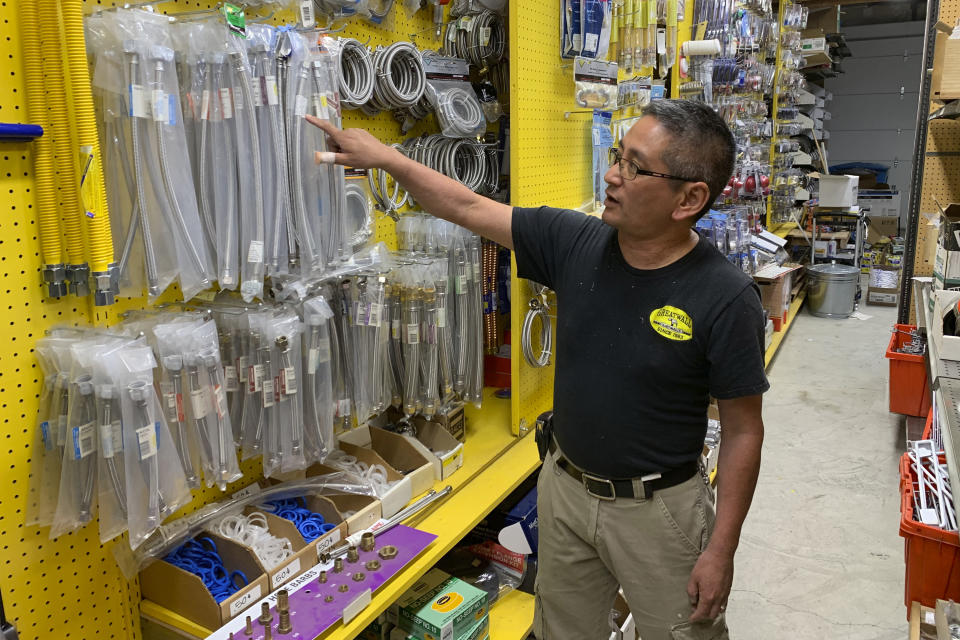 In this photo taken Wednesday, Aug. 28, 2019, Albert Chow, owner of Great Wall Hardware in San Francisco, points to steel faucet parts, whose prices have increased because of US tariffs on Chinese imports. He had to raise the price from $5.49 to $5.99. (AP Photo/Terry Chea)
