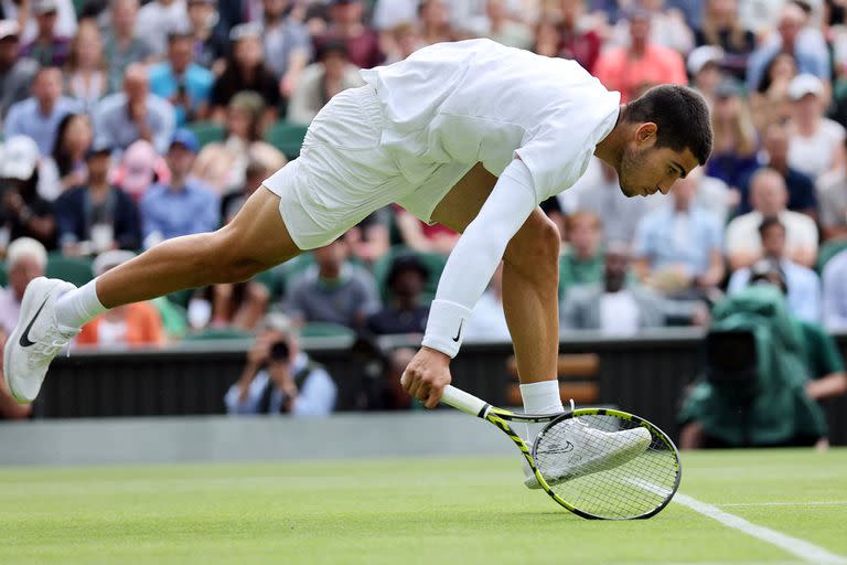 Spain's Carlos Alcaraz returns the ball to Italy's Jannik Sinner during their round of 16 men's singles tennis match on the seventh day of the 2022 Wimbledon Championships at The All England Tennis Club in Wimbledon, southwest London, on July 3, 2022. (Photo by Adrian DENNIS / AFP) / RESTRICTED TO EDITORIAL USE