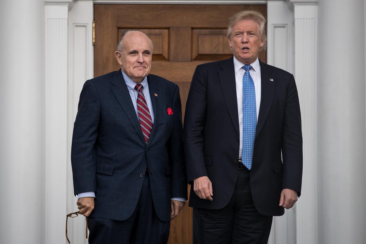 Former New York City mayor Rudy Giuliani stands with president-elect Donald Trump before their meeting at Trump International Golf Club, on 20 November 2016 in Bedminster Township, New Jersey (Getty Images)