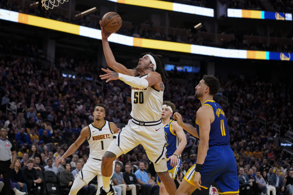 Denver Nuggets forward Aaron Gordon (50) shoots next to Golden State Warriors guard Klay Thompson (11) during the first half of an NBA basketball game Sunday, Feb. 25, 2024, in San Francisco. (AP Photo/Godofredo A. Vásquez)