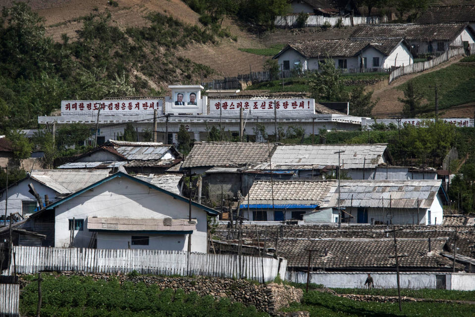 <p>North Korean buildings and houses, one with the images of late leaders Kim Il-Sung and Kim Jung-Il father, are seen in a village north of the border city of Dandong, Liaoning province, northern China on May 24, 2017 in Dandong, China. (Photo: Kevin Frayer/Getty Images) </p>