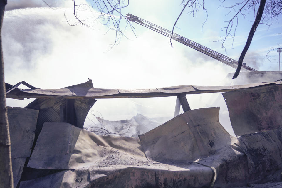 Firefighters continue to pour water on an industrial fire in Richmond, Ind., Wednesday, April 12, 2023. Authorities urged people to evacuate if they live near the fire. The former factory site was used to store plastics and other materials for recycling or resale. (AP Photo/Michael Conroy)