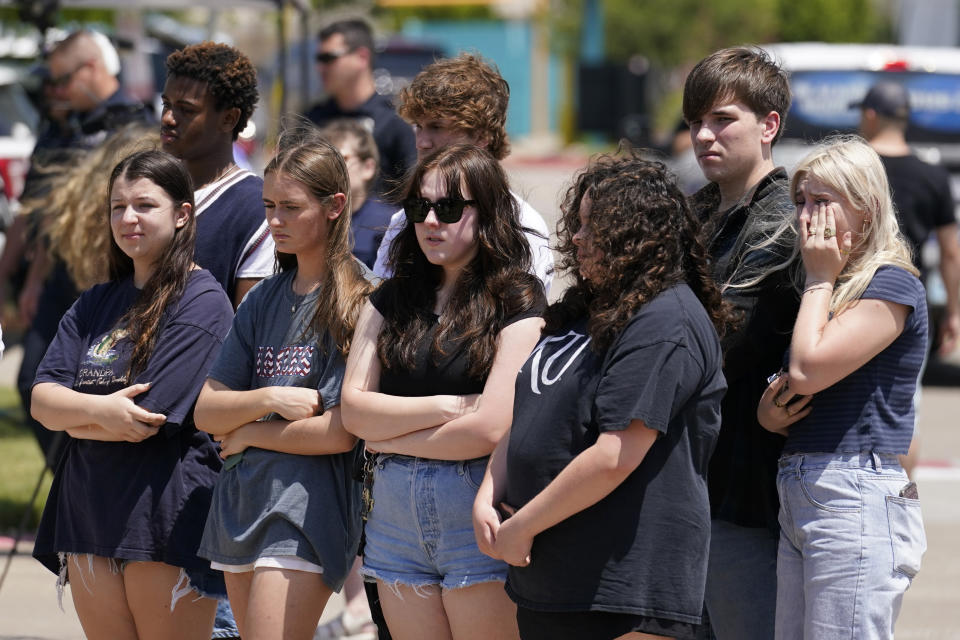 A group of young onlookers stand near a makeshift memorial by the mall where several people were killed several days earlier, Monday, May 8, 2023, in Allen, Texas. (AP Photo/Tony Gutierrez)