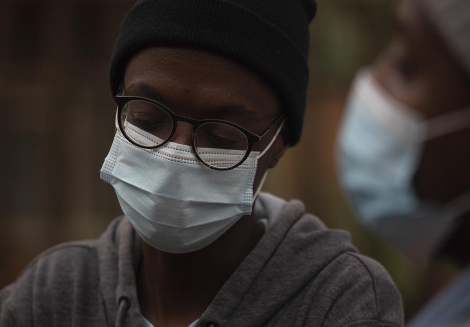 FILE - A student from the Tshwane University of Technology wears a face mask outside his residence in Pretoria, South Africa, Saturday, Nov. 27, 2021. The world is racing to contain a new COVID-19 variant, which appears to be driving a surge in South Africa and is casting a pall there. (AP Photo/Denis Farrell, File)