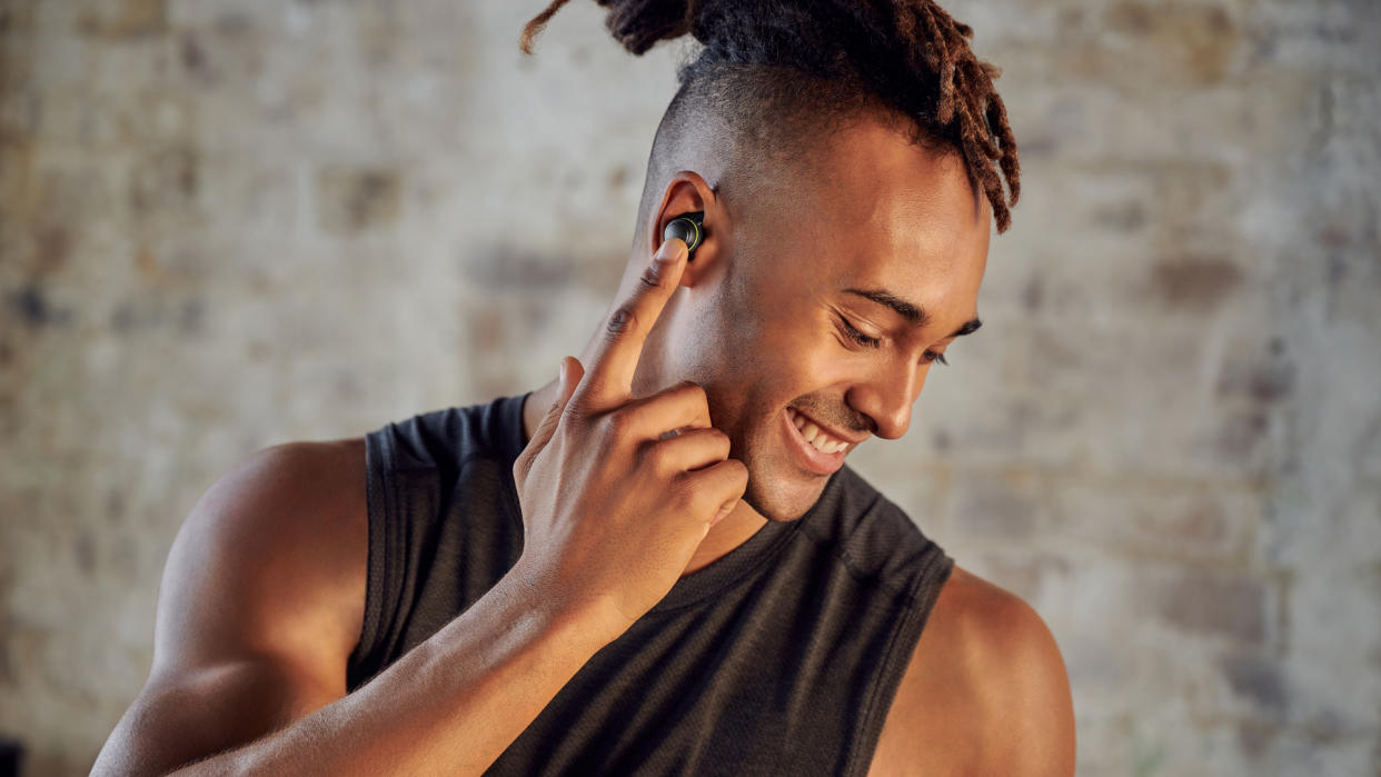  Handsome man adjusting the LG TONE Free fit UTF8 buds in his ear. 