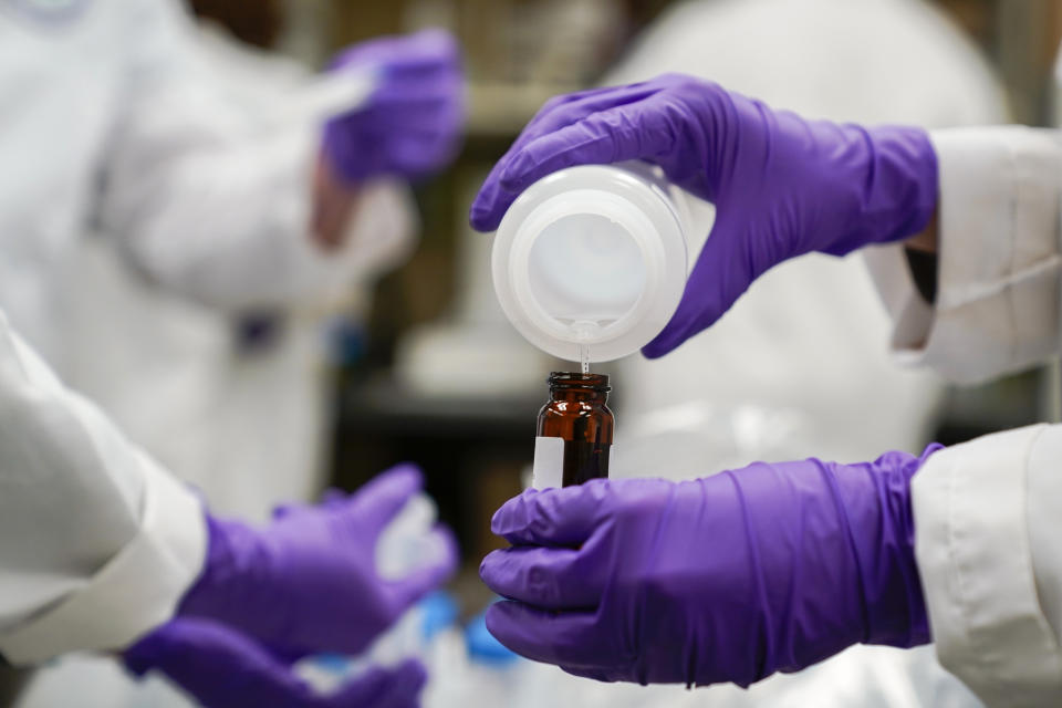 FILE - Eva Stebel, water researcher, pours a water sample into a smaller glass container for experimentation as part of drinking water and PFAS research at the U.S. Environmental Protection Agency Center For Environmental Solutions and Emergency Response on Feb. 16, 2023, in Cincinnati. The Biden administration on Wednesday, April 10, 2024, finalized strict limits on certain so-called “forever chemicals” in drinking water that will require utilities to reduce them to the lowest level they can be reliably measured. (AP Photo/Joshua A. Bickel, File)