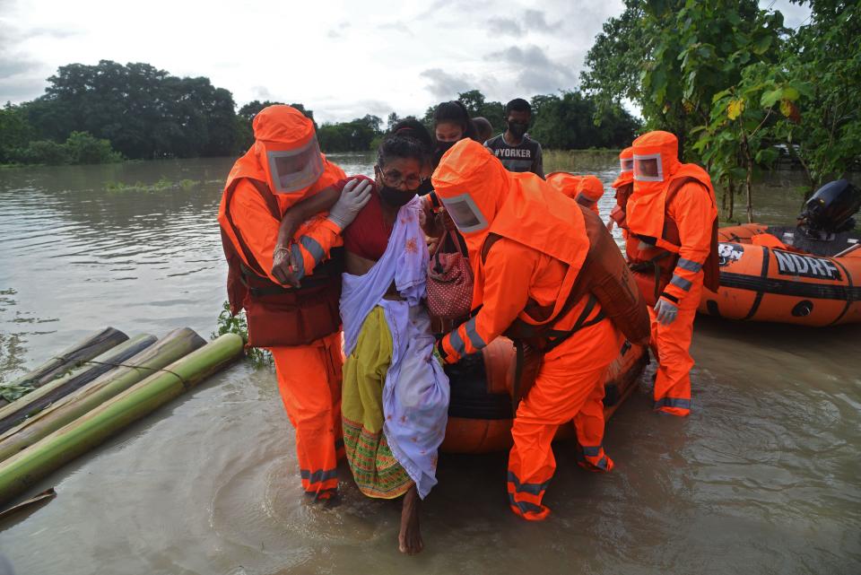 National Disaster Response Force (NDRF) personnel carry a sick woman during a rescue operation in a flood affected area due to monsoon rains, in Pathsala of Barpeta district, some 105 kms from Guwahati, the capital city of Indias northeastern state of Assam on July 12, 2020. (Photo by Biju BORO / AFP) (Photo by BIJU BORO/AFP via Getty Images)