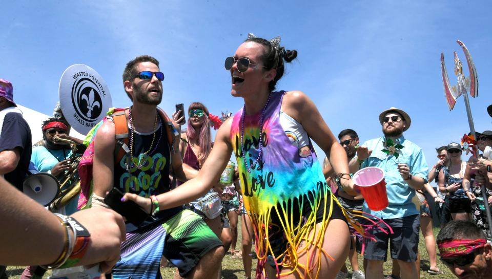 Music fans dance during a Mardi Gras parade in campground to kick off Bonnaroo at the Bonnaroo Music and Arts Festival in Manchester, Tenn, on Thursday, June 7, 2018.