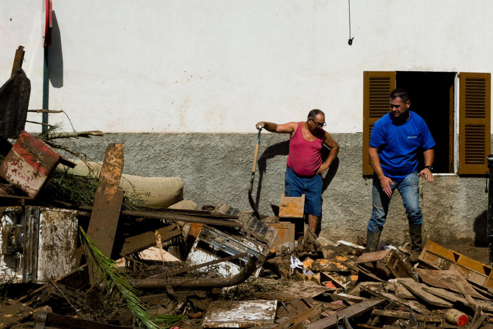 Residents remove destroyed furniture from their house affected by flooding in Sant Llorenc, Mallorca, Spain, Thursday, Oct. 11, 2018. Spanish rescuers have found the bodies of a German couple that went missing after a destructive flash flooding that killed at least 10 more earlier this week in Mallorca and are still looking for a missing child. (AP Photo/Francisco Ubilla)