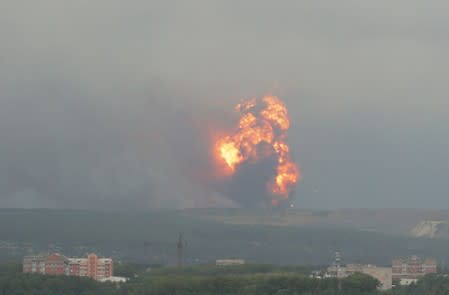 A view shows flame and smoke rising from the site of blasts at an ammunition depot in Krasnoyarsk region