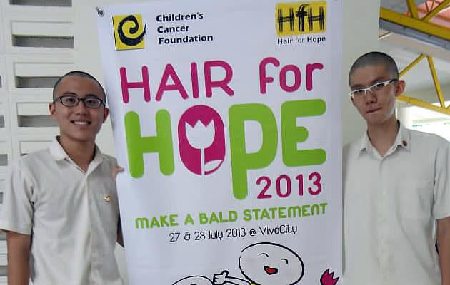 Two Victoria Junior College students posing with Hair for Hope banner. (Hair for Hope Facebook photo)