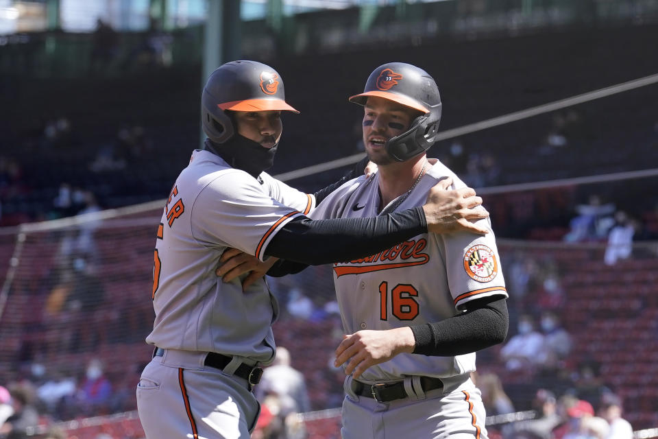 Baltimore Orioles' Anthony Santander, left, and Trey Mancini, right, celebrate after scoring on a double hit by teammate Maikel Franco in the first inning of a baseball game against the Boston Red Sox, Sunday, April 4, 2021, in Boston. (AP Photo/Steven Senne)