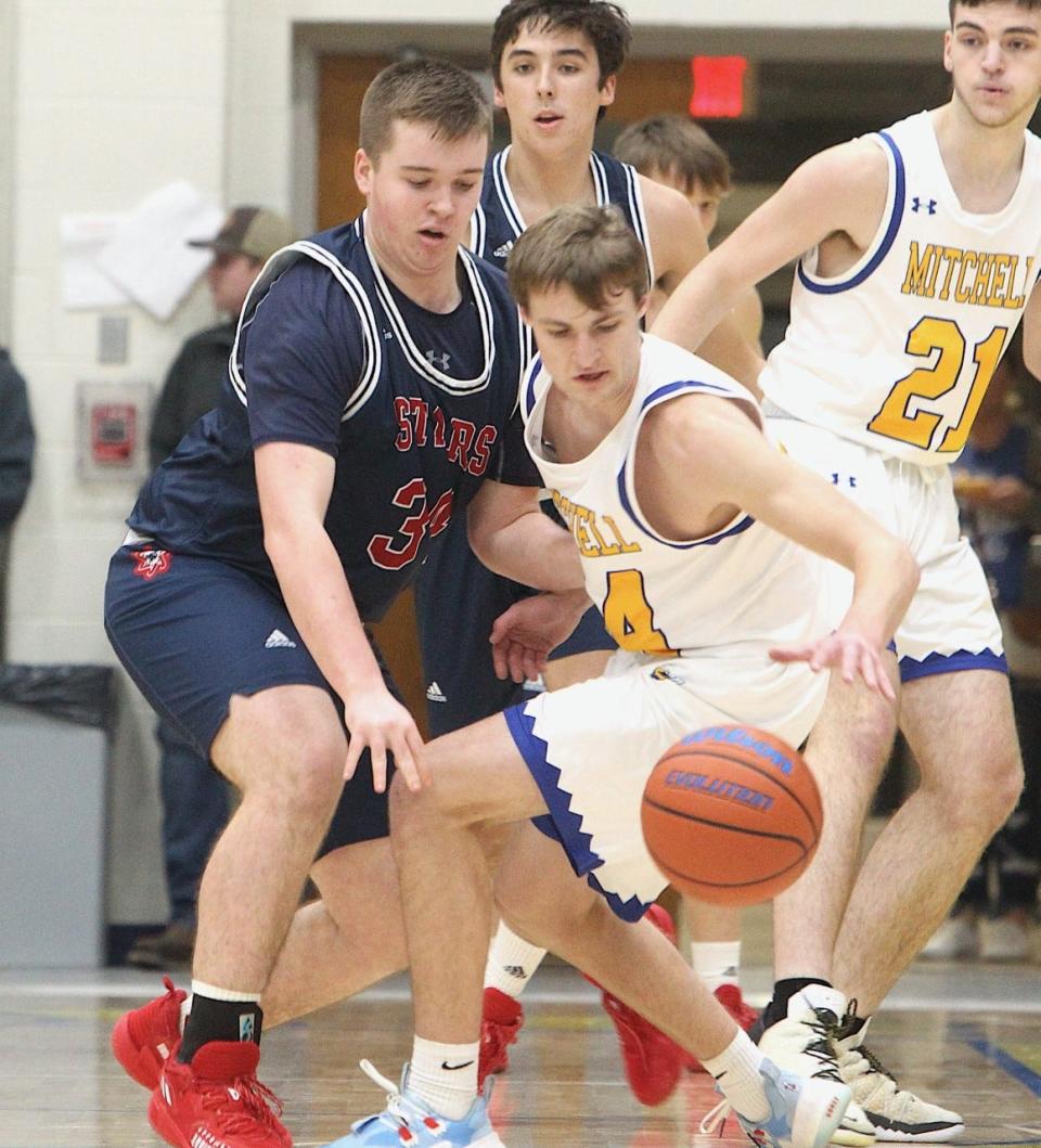 BNL junior Jett Jones (34) defends Mitchell senior Nick Mundy Tuesday night. Jones scored a career-high 14 points to lead a big win.