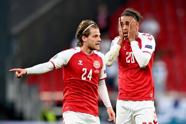 Denmark’s Yussuf Poulsen, right, and Mathias Jensen react after seeing Eriksen collapse