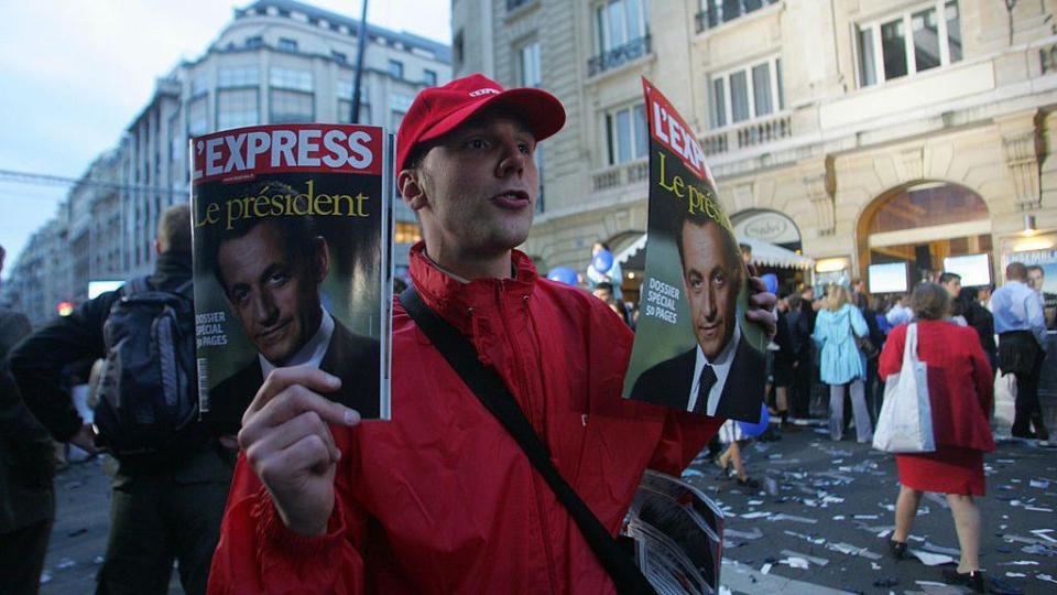 Un hombre vende la revista en la calle.