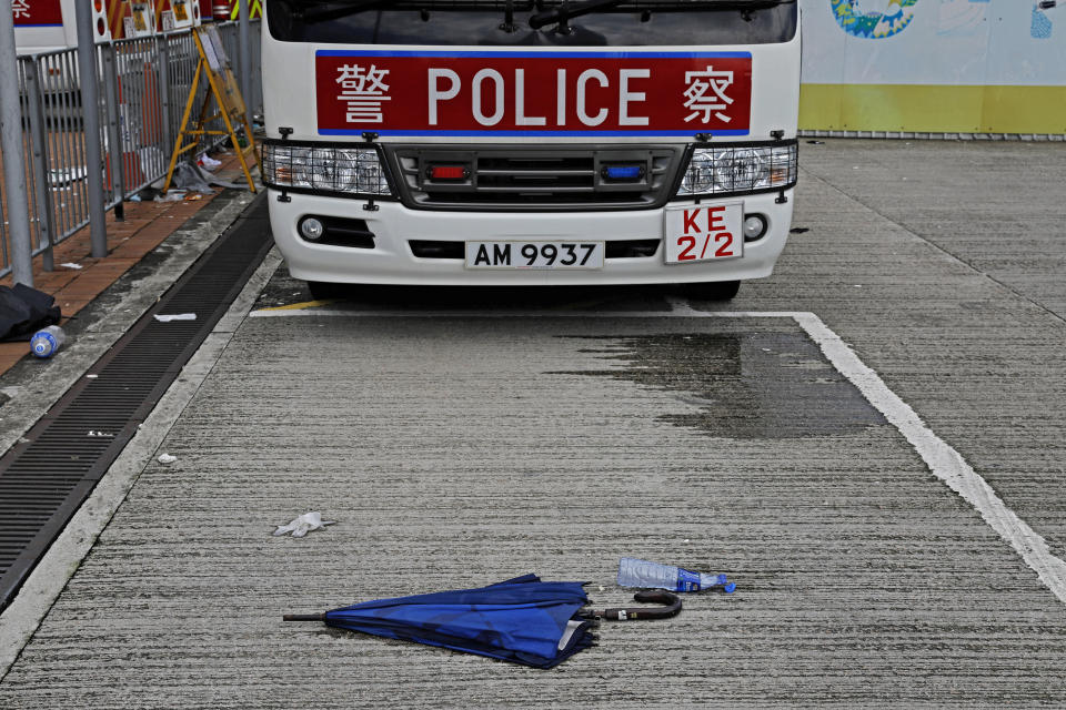 In this Friday, June 14, 2019, photo, a broken umbrella left in the aftermath of Wednesday's violent protest against proposed amendments to an extradition law is seen in Hong Kong. Umbrellas became a symbol of protest in Hong Kong in 2014 after demonstrators used them to shield themselves from both police pepper spray and a hot sun. Five years later, umbrellas were out in force again on Wednesday as thousands of protesters faced off with police outside the legislature. (AP Photo/Vincent Yu)