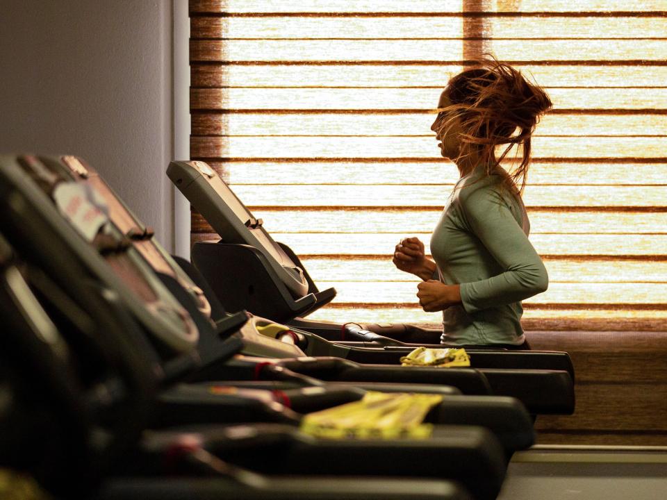 Woman runs on treadmill.