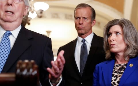 John Thune, the Senate Republican whip, watches as as Mitch McConnell, the Senate Republican leader, speaks on Tuesday - Credit: REUTERS/Tom Brenner