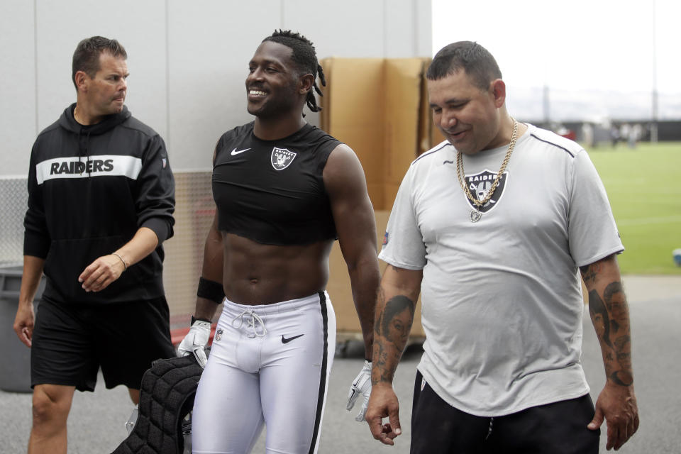 Oakland Raiders' Antonio Brown, center, walks off the field after NFL football practice in Alameda, Calif., Tuesday, Aug. 20, 2019. (AP Photo/Jeff Chiu)
