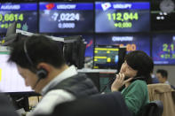 A currency trader talks on the phone at the foreign exchange dealing room of the KEB Hana Bank headquarters in Seoul, South Korea, Friday, Feb. 21, 2020. Asian stock markets have followed Wall Street lower after a rise in virus cases in South Korea refueled investor anxiety about China's disease outbreak. (AP Photo/Ahn Young-joon)