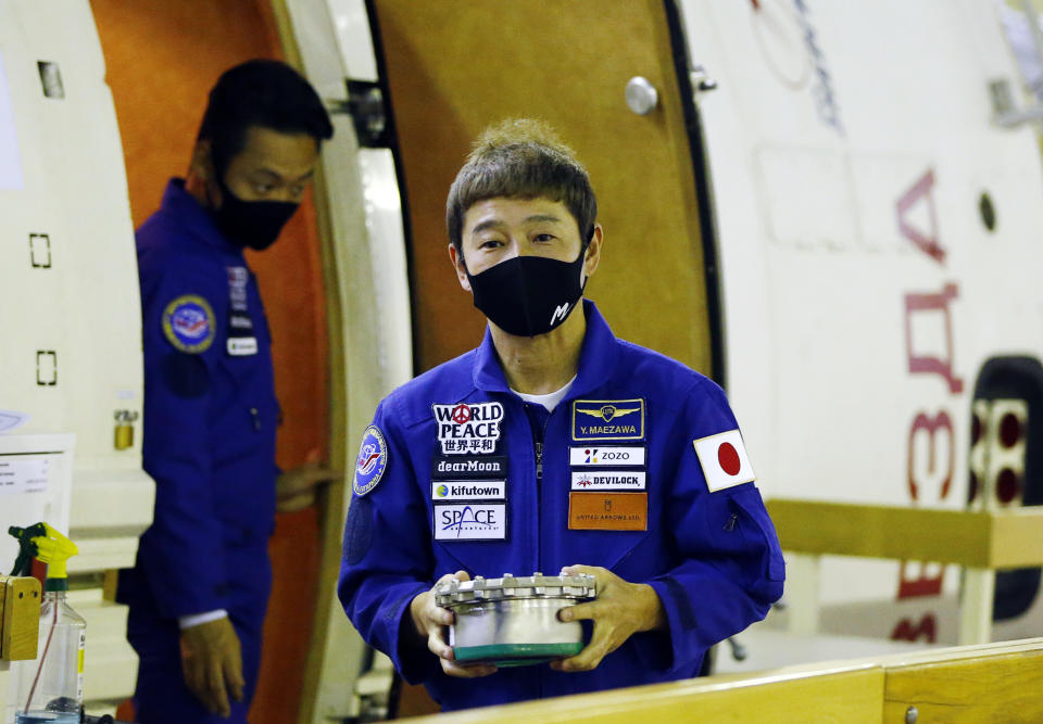 Space flight participant Yusaku Maezawa, foreground, attends a training ahead of the expedition to the International Space Station, at the Gagarin Cosmonauts' Training Center in Star City outside Moscow, Russia, Thursday, Oct. 14, 2021. A Japanese fashion tycoon who's booked a SpaceX ride to the moon is going to try out the International Space Station first. Yusaku Maezawa announced that he's bought two seats on a Russian Soyuz capsule. He'll blast off in December on the 12-day mission with his production assistant and a professional cosmonaut. (Shamil Zhumatov/Pool Photo via AP)