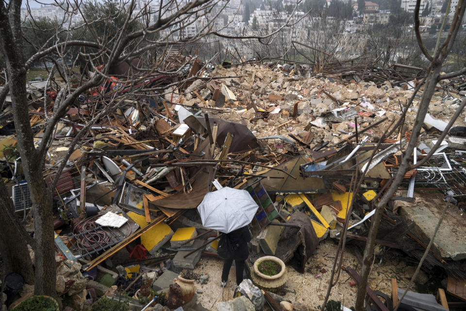 Una mujer observa las ruinas de una casa palestina demolida por el municipio de Jerusalén en el barrio de Sheikh Jarrah, en Jerusalén oriental, el 19 de enero de 2022. La policía israelí desalojó a los residentes palestinos de la propiedad en disputa y demolió el inmueble, días después de un enfrentamiento tenso. (AP Foto/Mahmoud Illean)