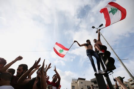 Demonstrators carry national flags during a protest targeting the government over an economic crisis in the port city of Sidon