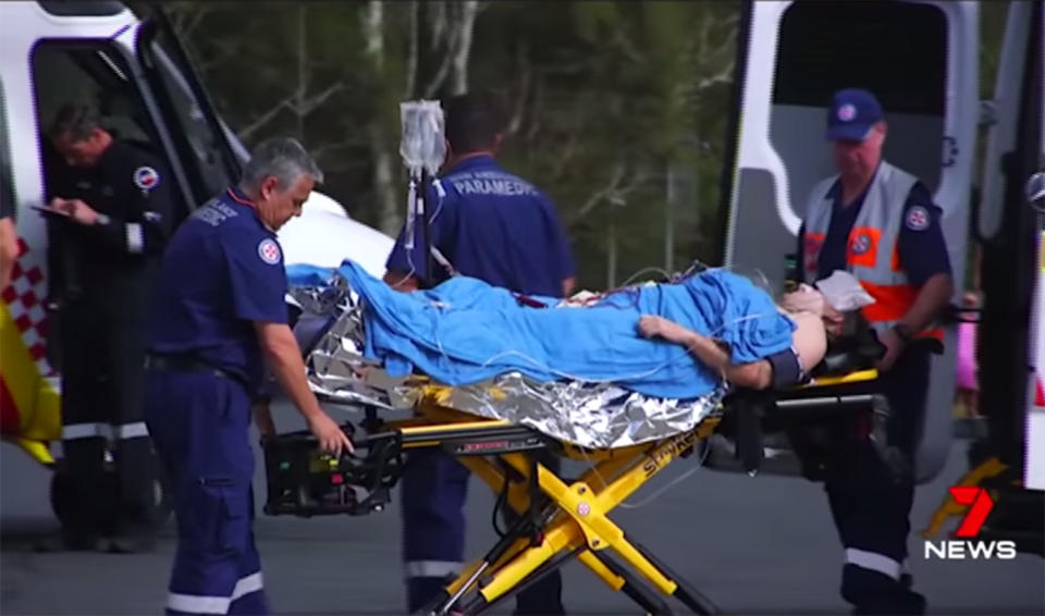 A shark attack victim is transported on a stretcher after the attack at Nambucca Heads on Sunday morning. 