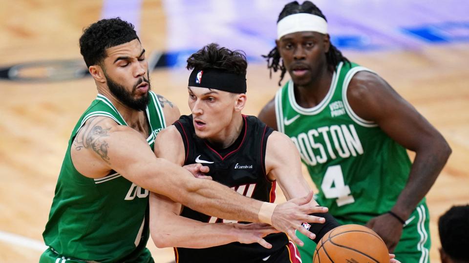 Tyler Herro (14) drives the ball past Boston Celtics forward Jayson Tatum (0)