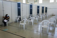 A woman sits in the nearly empty waiting room of a vaccination center in Lisbon, Tuesday, Sept. 21, 2021. As Portugal nears its goal of fully vaccinating 85% of the population against COVID-19 in nine months, other countries want to know how it was able to accomplish the feat. A lot of the credit is going to Rear Adm. Henrique Gouveia e Melo. (AP Photo/Armando Franca)