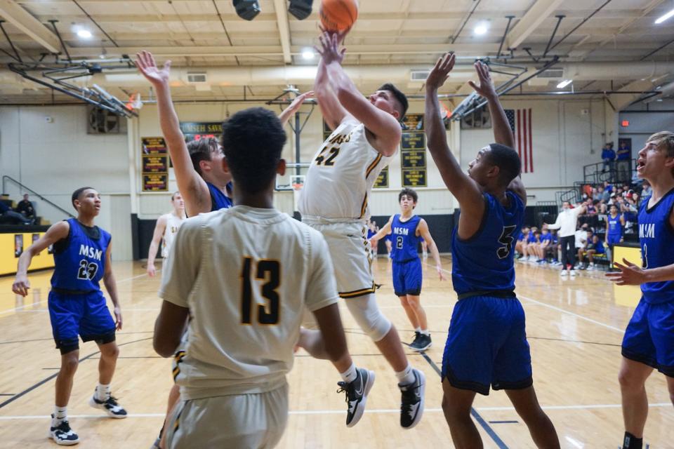 Senior Brennon Carter (42) goes up for the layup over two Mount St. Mary defenders Tuesday night.