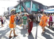 �Felix Anaye, 32, portraying Jesus Christ, carries a wooden cross while he is whipped by a man portraying a Roman soldier during a procession ahead of Good Friday in Mandaluyong city, metro Manila. Penitents will be nailed to a cross on Good Friday in a display of religious devotion in the Philippines, a predominantly Catholic country. Holy Week is celebrated in many Christian traditions during the week before Easter.