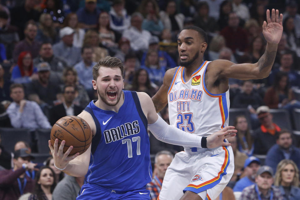 Dallas Mavericks forward Luka Doncic (77) drives past Oklahoma City Thunder guard Terrance Ferguson (23) during the first half of an NBA basketball game Tuesday, Dec. 31, 2019, in Oklahoma City. (AP Photo/Sue Ogrocki)