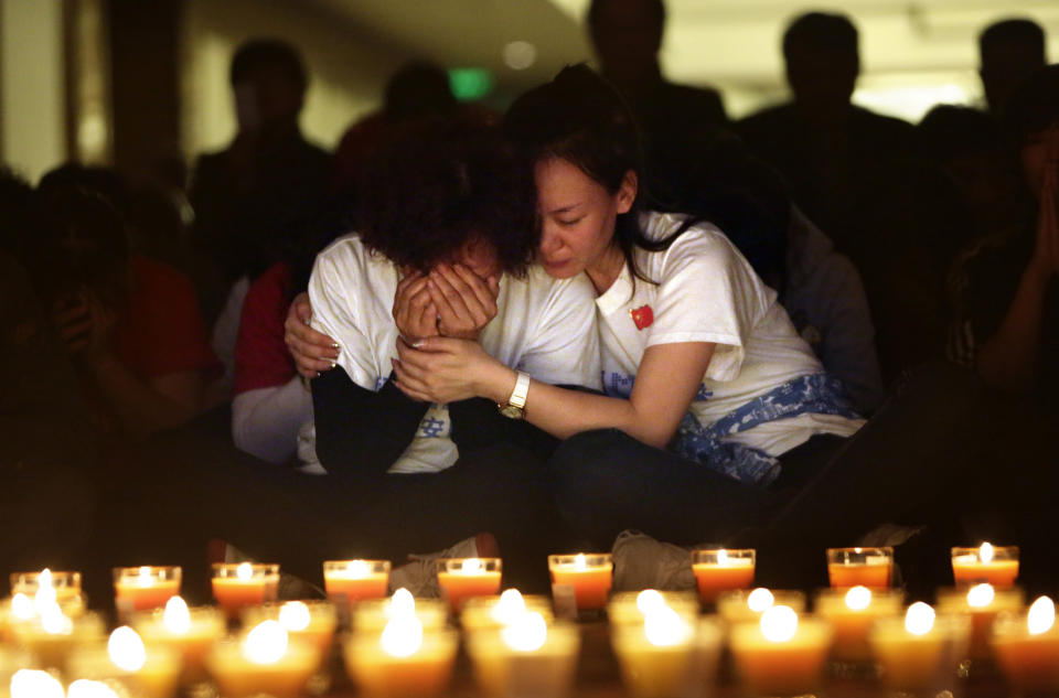 A family member cries as she and other relatives pray during a candlelight vigil for passengers aboard the missing Malaysia Airlines Flight 370 at Lido Hotel, in Beijing, on April 8, 2014, after a month of searching for the missing aircraft