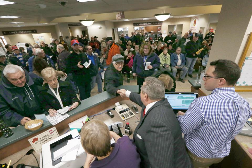 Greece Town Supervisor Bill Reilich, bottom, greets taxpayer Reno Pappano as hundreds flood into Greece Town Hall to prepay their town and county property taxes Friday, Dec. 29, 2017 in Greece. 