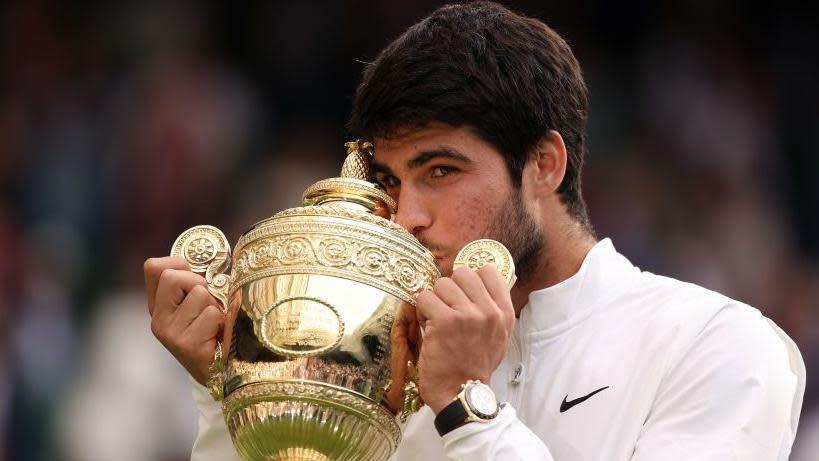 Carlos Alcaraz kisses the Wimbledon men's singles trophy