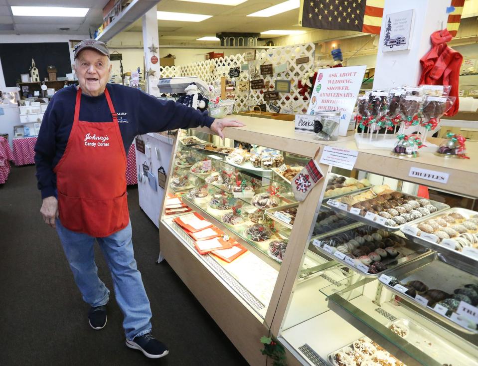 Johnny Biagioni, the owner of Johnny’s Candy Corner for four decades, smiles with his customers. His humor and kindness make him a beloved figure in the community.
