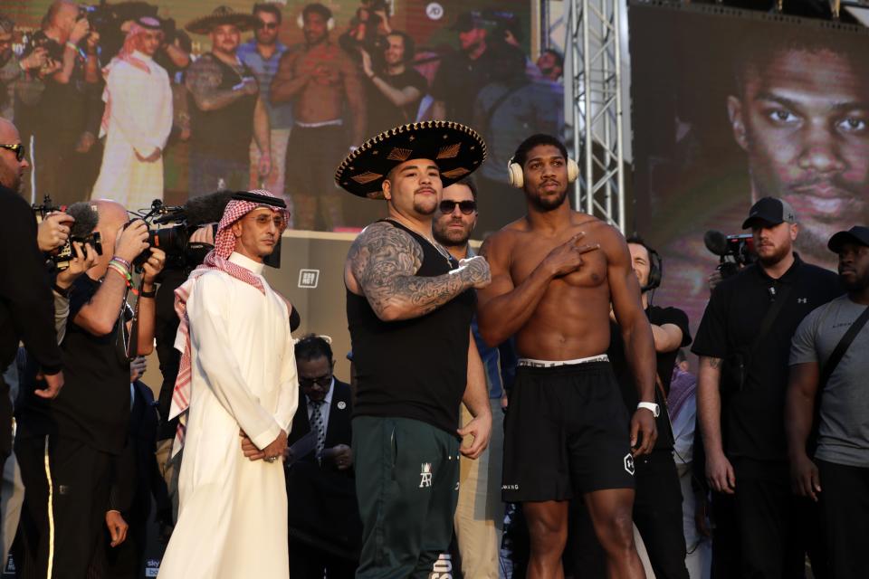 Heavyweight boxers Anthony Joshua of Britain, right, and Andy Ruiz Jr. of Mexico pose during a weigh-in at Faisaliah Center, in Riyadh, Saudi Arabia, Friday, Dec. 6, 2019. The first ever heavyweight title fight in the Middle East, has been called the "Clash on the Dunes." Will take place at the Diriyah Arena on Saturday. (AP Photo/Hassan Ammar)
