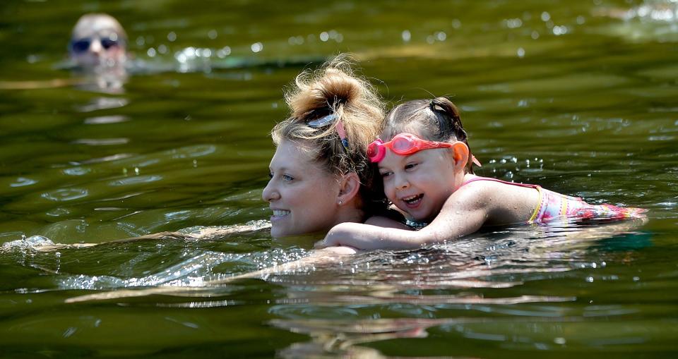 Summer Killgoard, 4, goes for a ride on her mother Ilana's back at Framingham's Saxonville Beach in this 2020 photo.