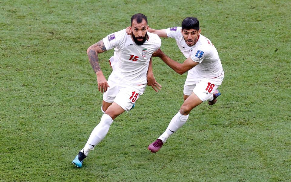 Rouzbeh Cheshmi (L) of Iran celebrates with teammate Mehdi Torabi after scoring the opening goal during the FIFA World Cup 2022 group B soccer match between Wales and Iran at Ahmad bin Ali Stadium - Shutterstock