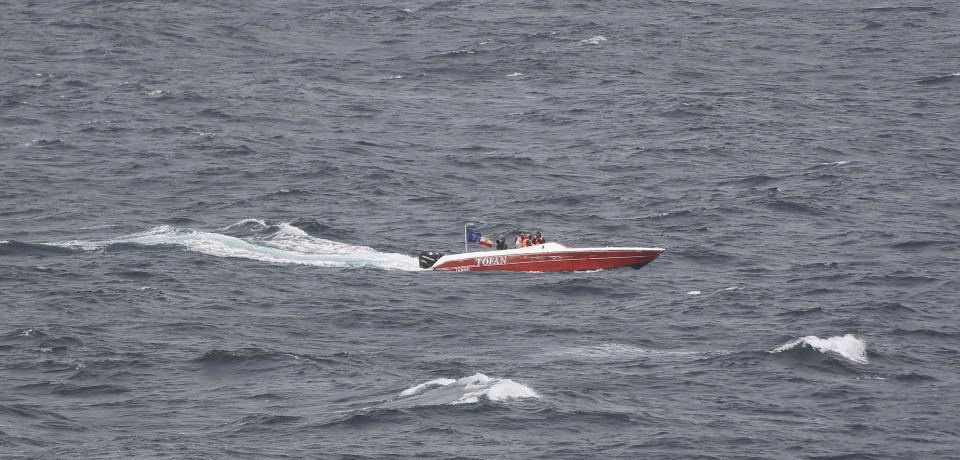 In this Tuesday, March 21, 2017 photograph, members of Iran's paramilitary Revolutionary Guard watch the USS George H.W. Bush as it travels through the Strait of Hormuz. The arrival of the nuclear-powered aircraft carrier to the Persian Gulf marks the first such deployment under new U.S. President Donald Trump. (AP Photo/Jon Gambrell)