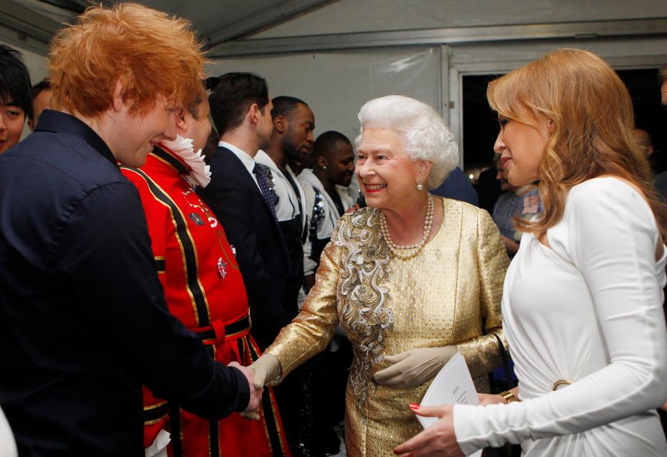 Queen Elizabeth II is introduced to Ed Sheeran (L) by Kylie Minogue
