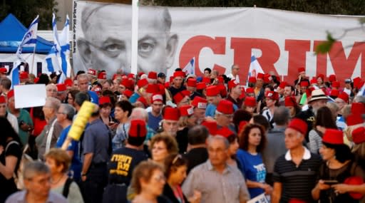 Thousands of Israelis, including Blue and White leader Benny Gantz, demonstrate against their "crime minister" in Tel Aviv, many of them wearing fezzes in protest at what they see as Netanyahu's attempt to rule the country like an Ottoman sultan