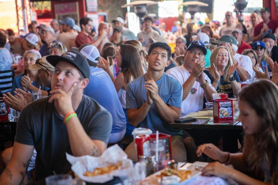 People seated at tables look up in an eatery.