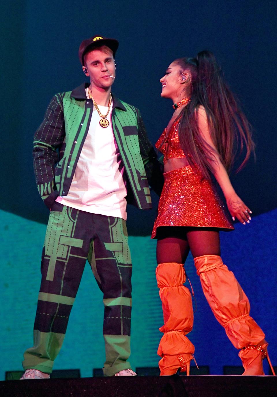 Justin Bieber and Ariana Grande on stage for a performance in green and orange outfits, and they look amazing.