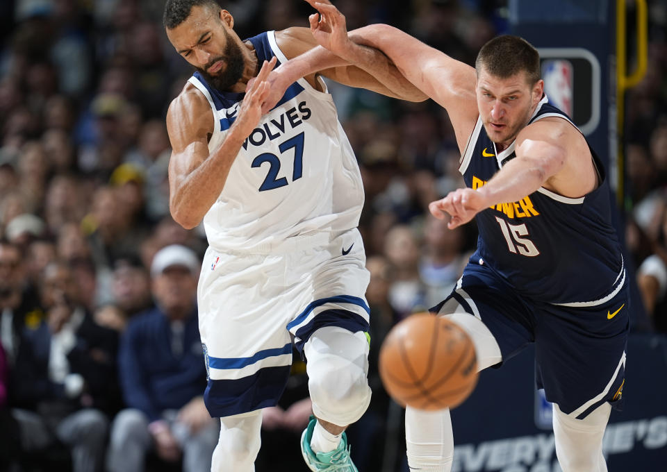 Denver Nuggets center Nikola Jokic, right, pushes Minnesota Timberwolves center Rudy Gobert while they pursue the ball during the second half of an NBA basketball game Wednesday, April 10, 2024, in Denver. (AP Photo/David Zalubowski)