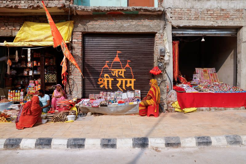 Shopkeepers are seen on the pavement on a newly revamped road near the site of the under construction of the Hindu Ram Temple in Ayodhya